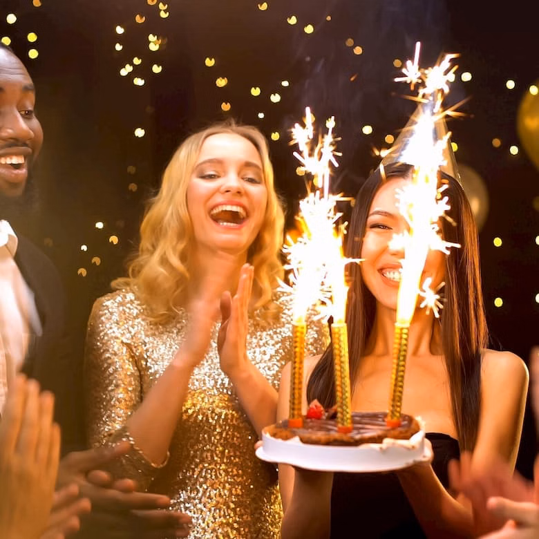 Happy woman with cake at birthday party
